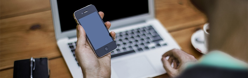 Man using mobile device and laptop